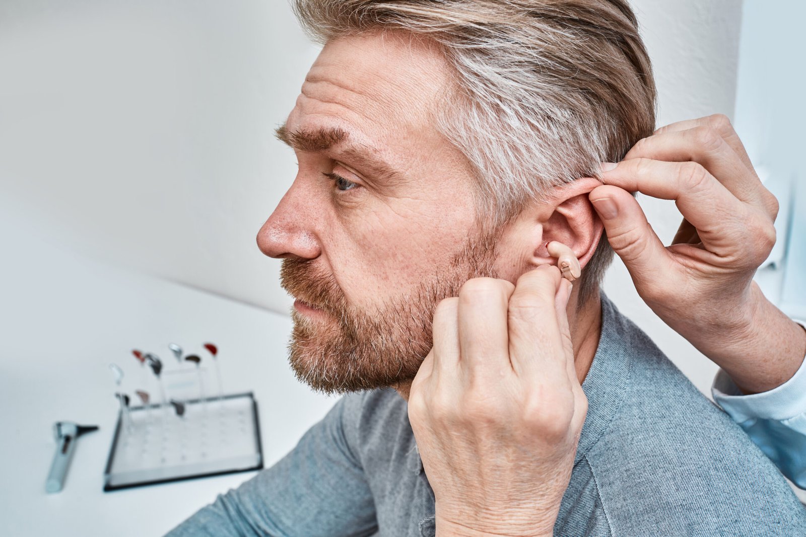 audiologist inserting ite hearing aid in adult man 2025 04 01 20 39 02 utc scaled